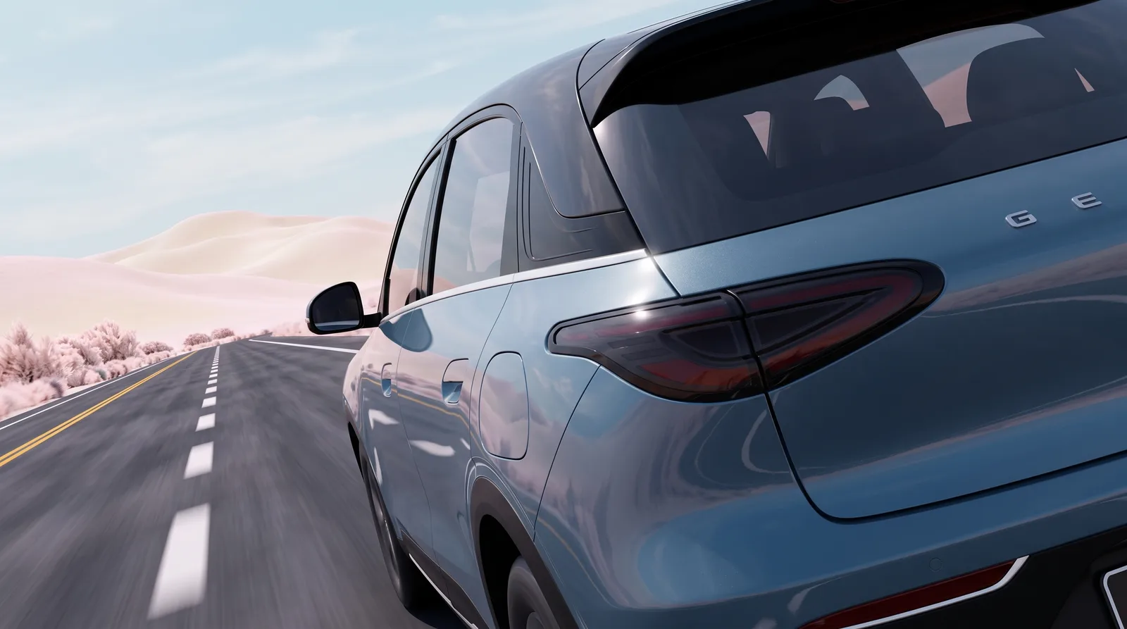 沙漠沙丘公路上一辆钢蓝色 SUV 的车尾侧面