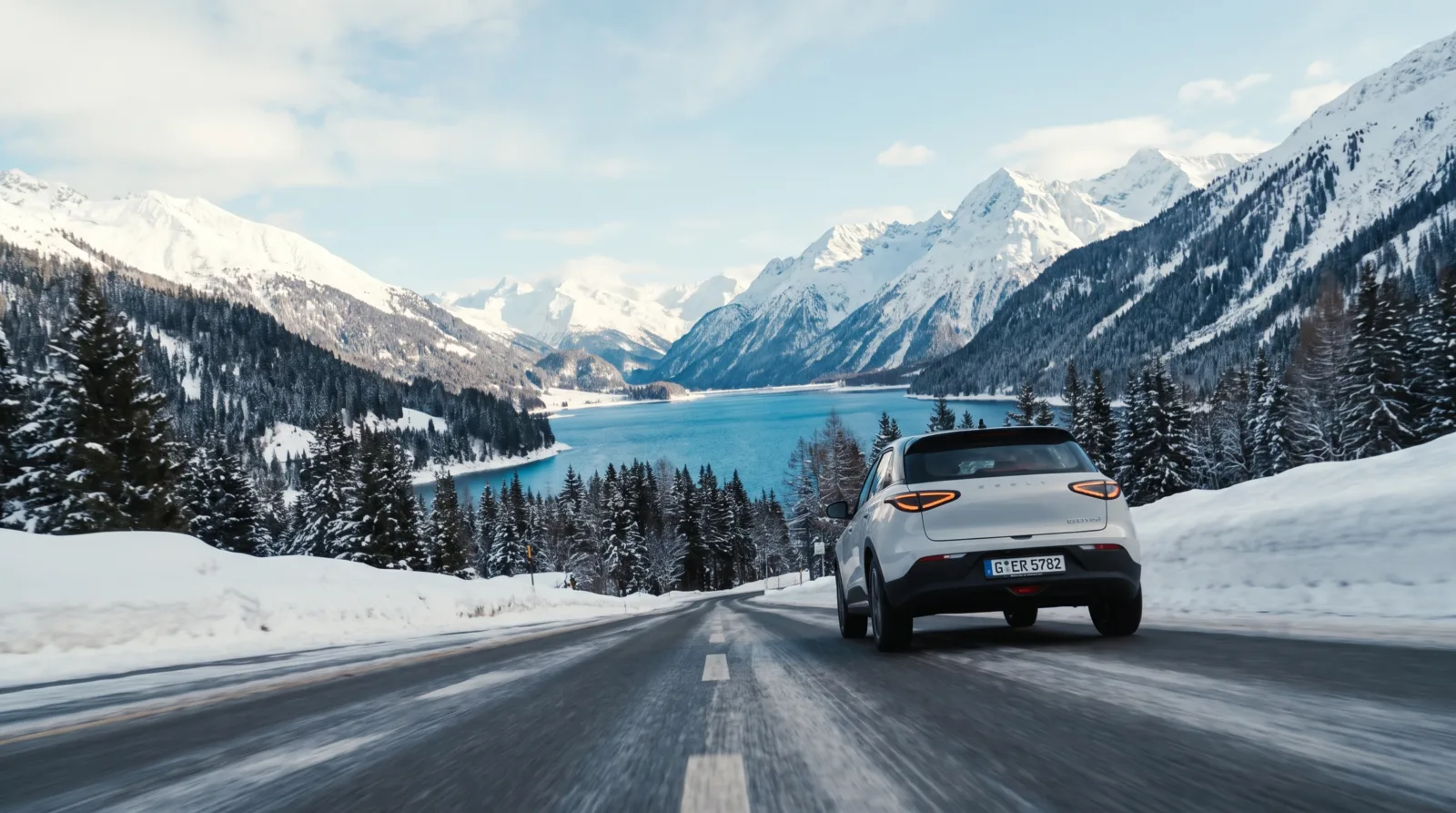 绿松石色湖泊上方，积雪高山公路上的一辆白色 SUV